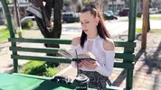 милашка читает книгу в парке